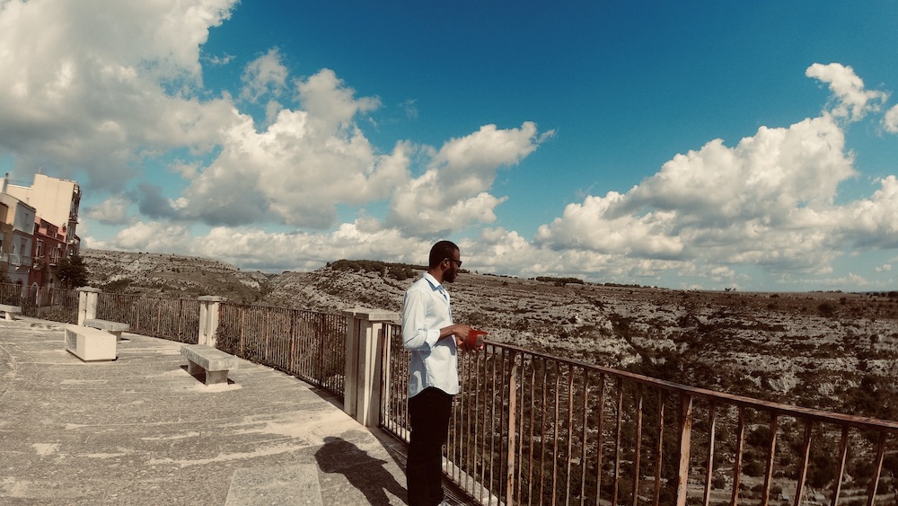 My Nigerian husband standing by a cliff in Ragusa, Sicily, Italy.